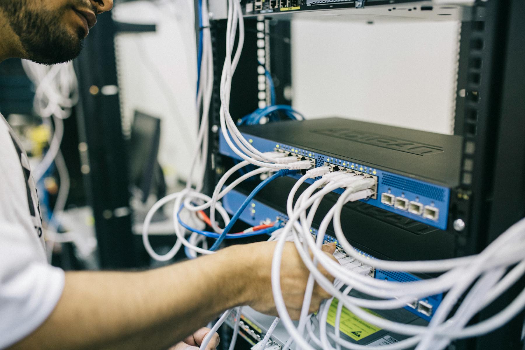 Technician working with network cables and equipment