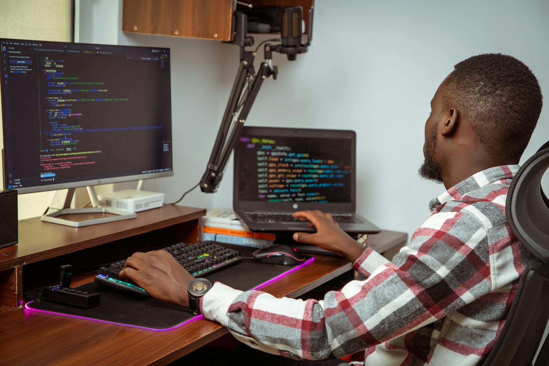 Software developer working at a desk with code on screens